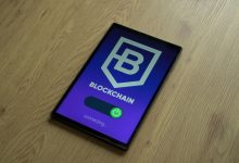 Tablet exibe um conceito de blockchain sobre uma superfície de madeira.